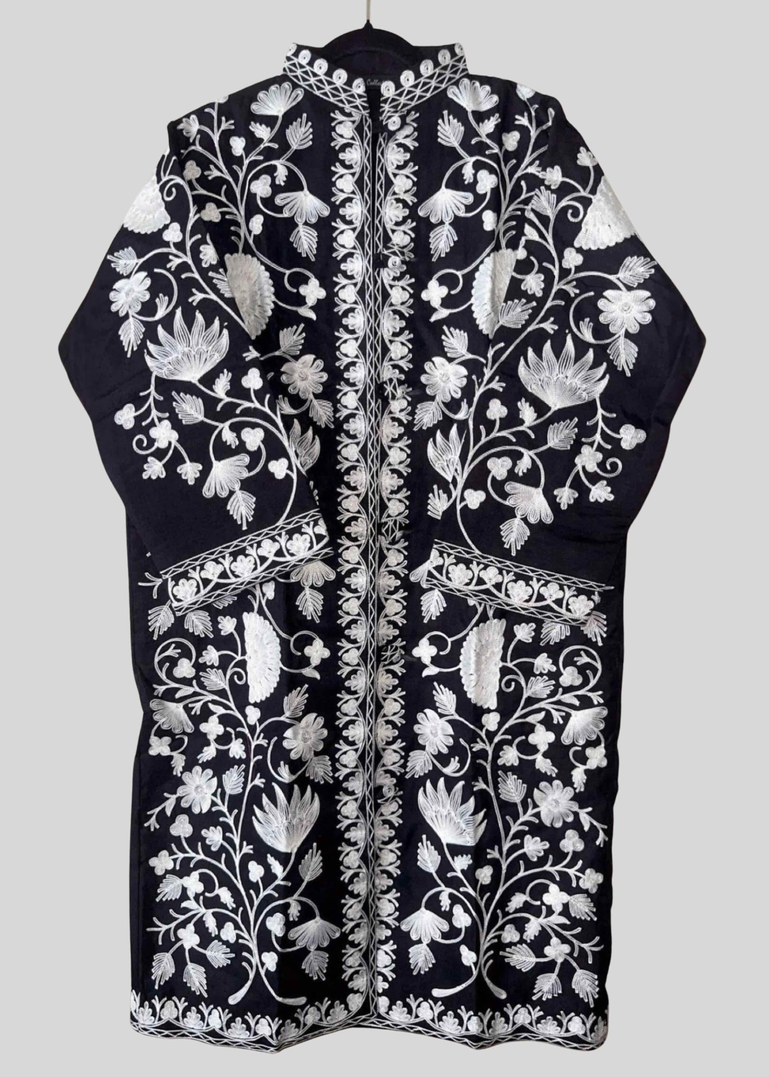 Black embroidered garment with white floral patterns on a light gray background