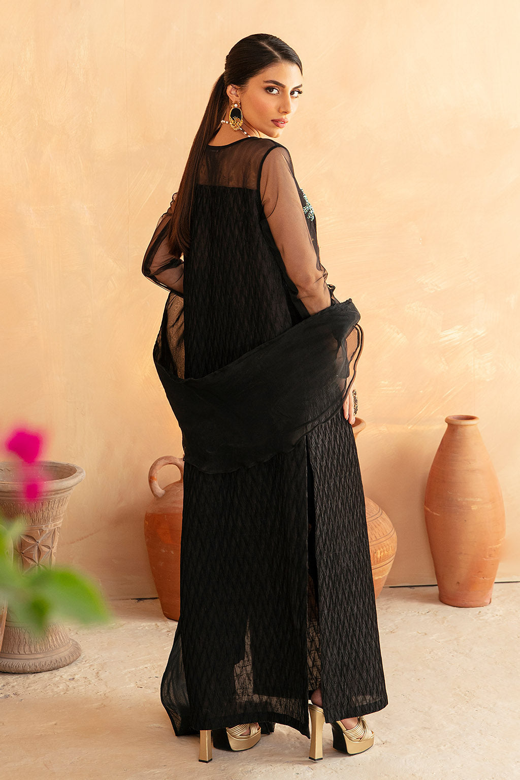 Woman wearing a black saree with a plain background
