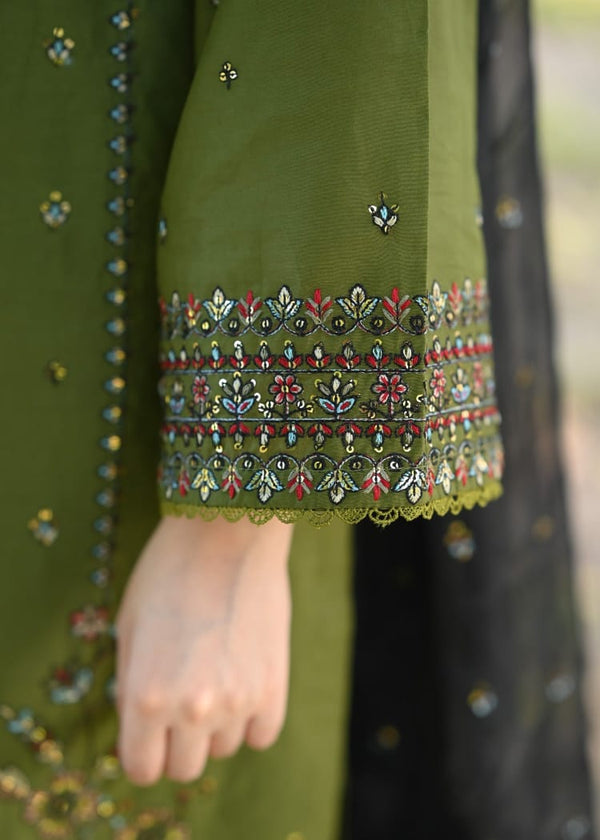 Close-up of a green embroidered garment with intricate patterns.