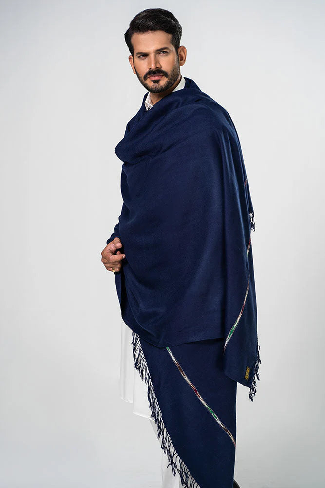 Man wearing a navy blue shawl with white patterns on a white background